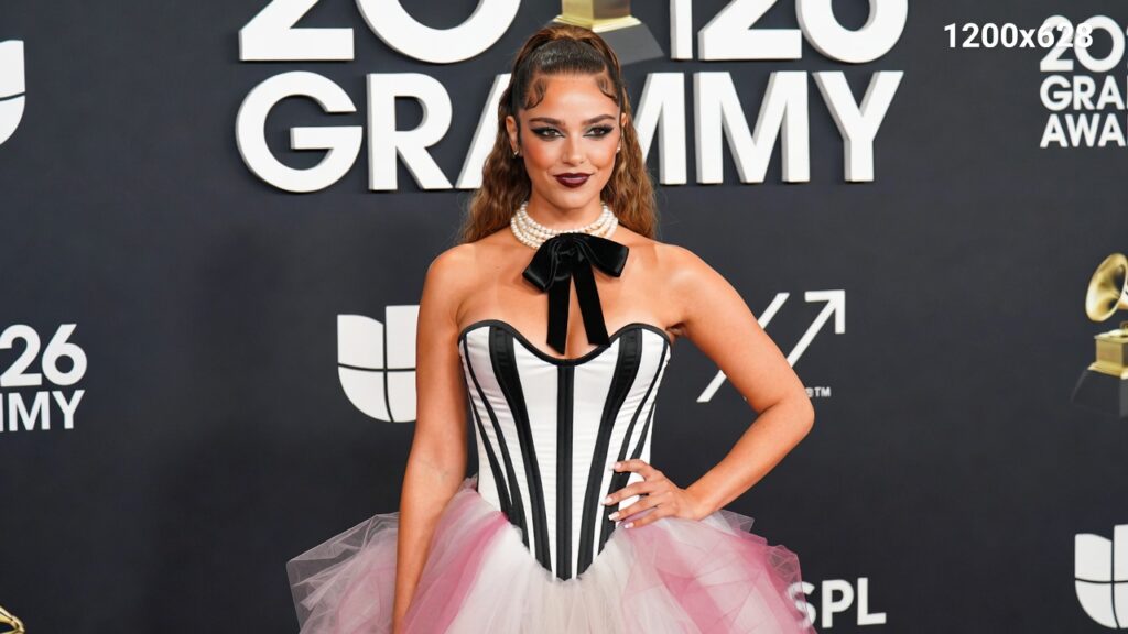 Chappell Roan on the red carpet at the 2026 Grammys, wearing a glamorous maroon high-fashion gown, with sparkling lights and elegant silhouette.