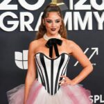 Chappell Roan on the red carpet at the 2026 Grammys, wearing a glamorous maroon high-fashion gown, with sparkling lights and elegant silhouette.