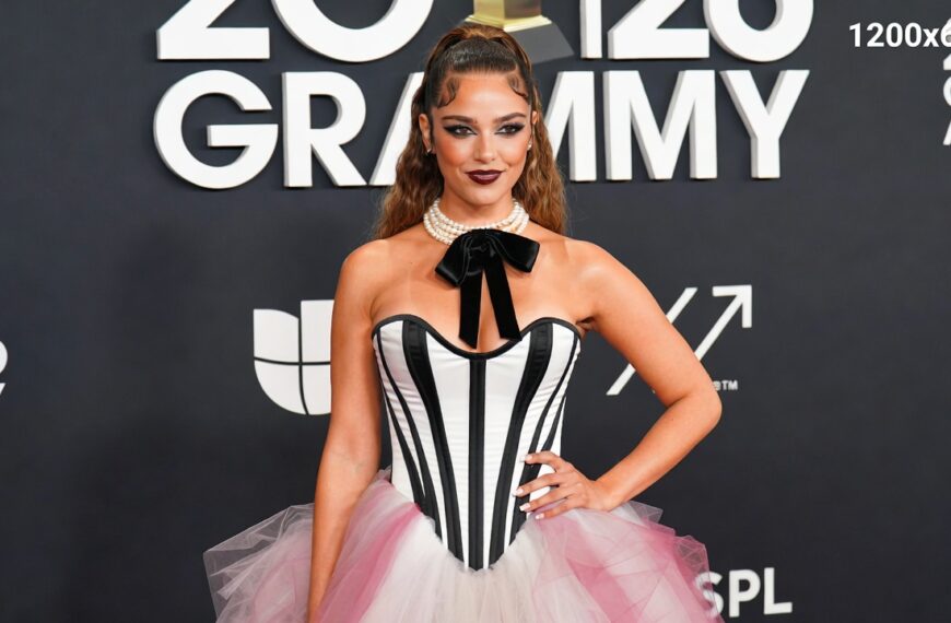 Chappell Roan on the red carpet at the 2026 Grammys, wearing a glamorous maroon high-fashion gown, with sparkling lights and elegant silhouette.