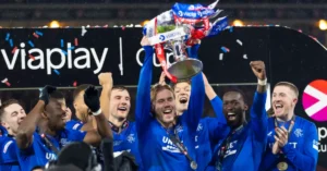Rangers players lift the trophy in ecstatic celebration with confetti at Ibrox after dominant win, Scottish Premiership 2026