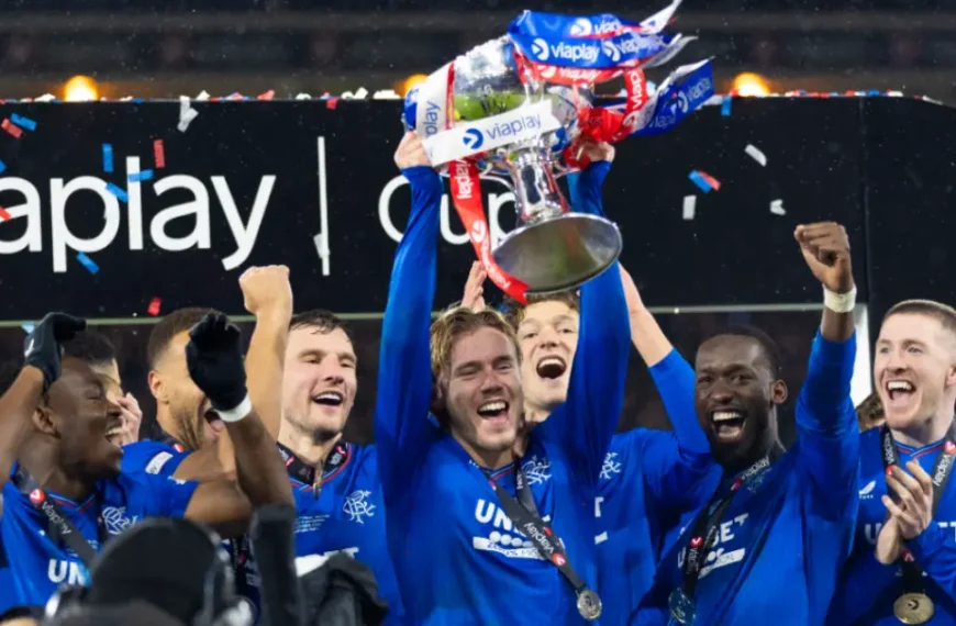 Rangers players lift the trophy in ecstatic celebration with confetti at Ibrox after dominant win, Scottish Premiership 2026